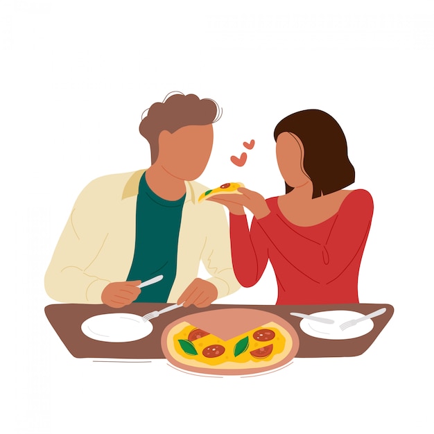 Woman feeding boyfriend a slice of pizza