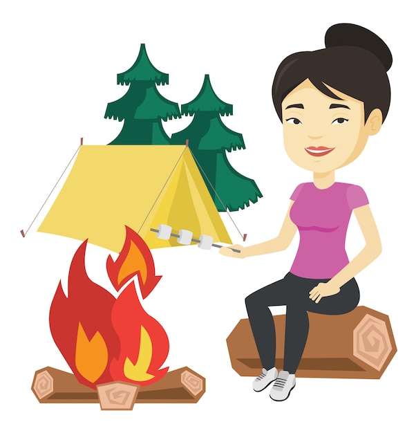 Woman roasting marshmallow over campfire.