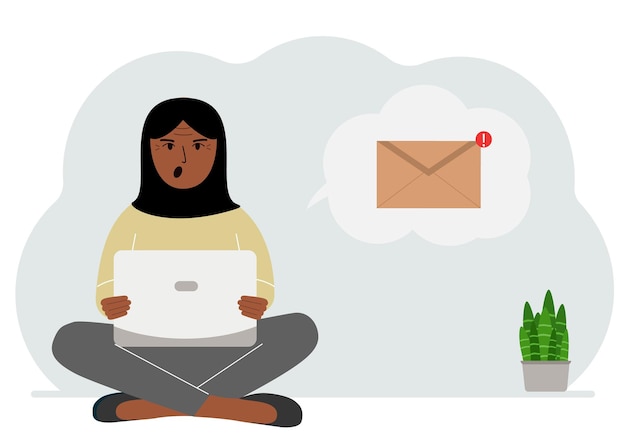 Una donna siede a gambe incrociate lavorando con un laptop e apre un'e-mail il concetto di corrispondenza di lavoro educativo