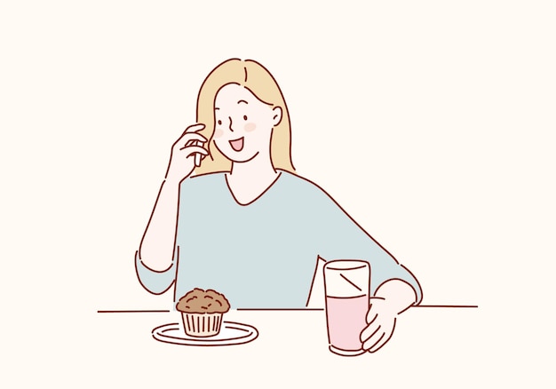 Vector a woman sits at a table with a cup of muffin and a glass of water.