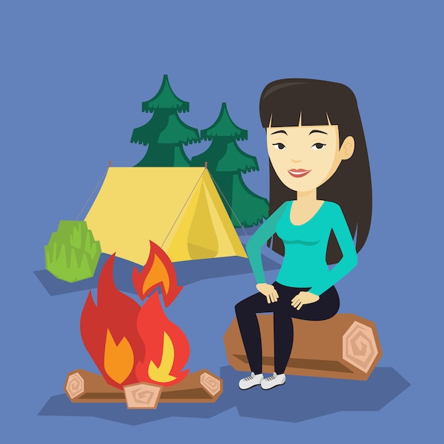 Woman sitting on log near campfire in the camping.