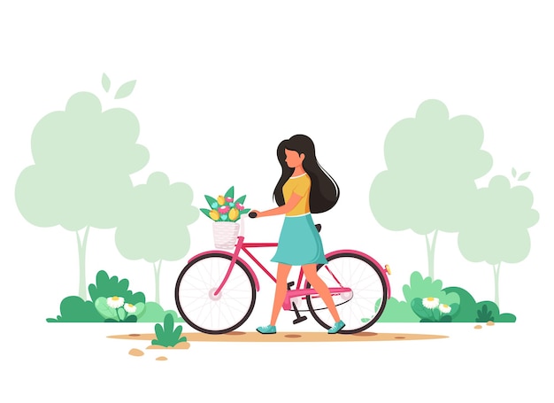 Woman with a bike with flowers in the basket in spring park