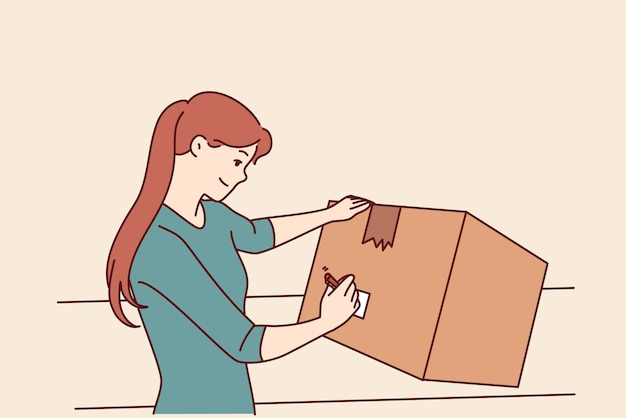 Woman with cardboard box signs package before sending goods through postal service or courier