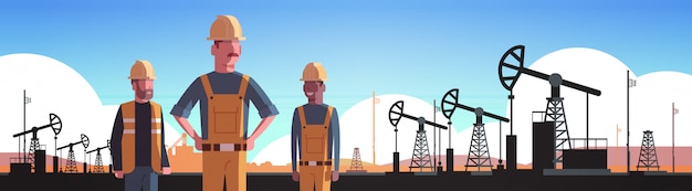 Работники в оранжевой форме работают на нефтяной буровой установке Pumpjack нефтедобывающая промышленность торговля нефтяной промышленности концепция портрет горизонтальный
