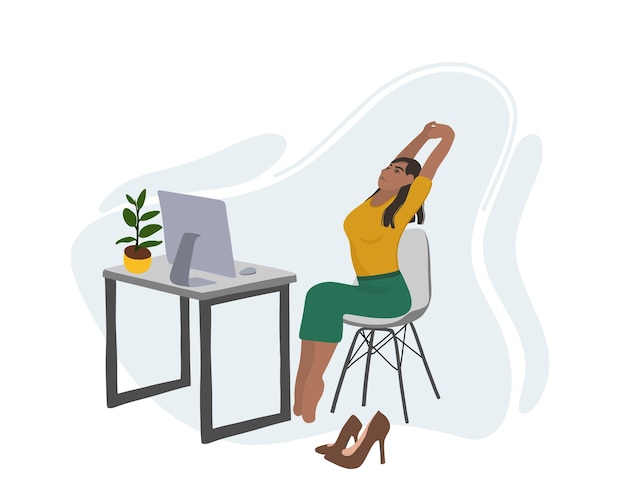 A young African American woman doing exercises and warming up near a table with a computer.