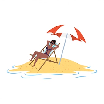 Giovane donna afro che si rilassa sulla spiaggia messa in sedia ed ombrello