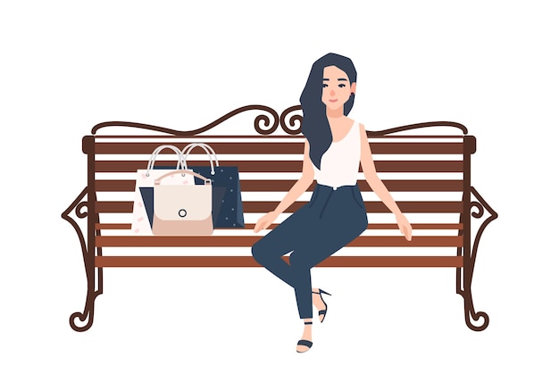 Молодые веселые длинноволосые женщины, одетые в элегантную одежду, сидят на скамейке рядом с сумками с покупками и расслабляются после покупок