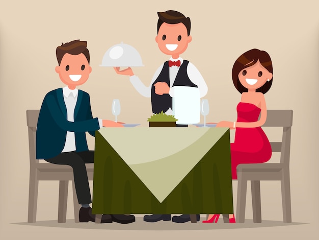a young couple having dinner in a restaurant. man and woman sitting at the table, the waiter brought a dish.