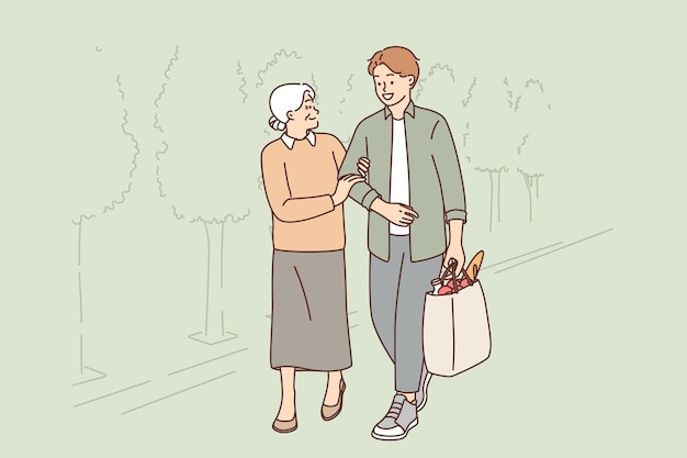 Young man helps old woman to carry heavy bag from grocery store for concept of respect for pensioners old woman walks down street with grandson carrying package and smiling looks at grown guy