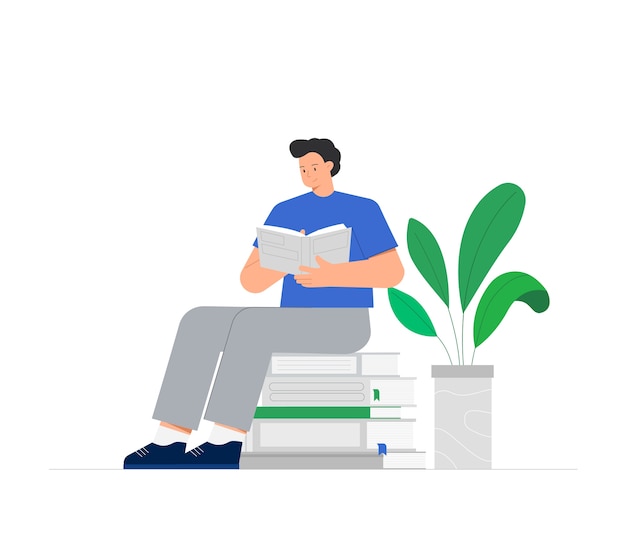 Young man is sitting on a stack of books and reading a book, near green flower in pot.