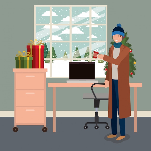 Young man with pine tree and gifts in the office