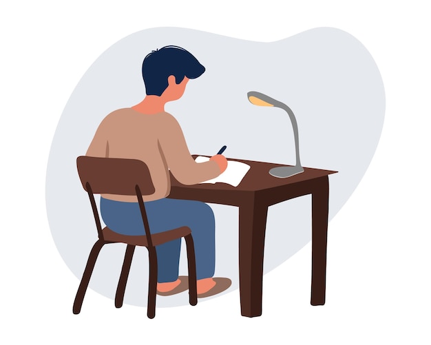 A young man at the workplace writes an article or works with documents in the evening with the lamp