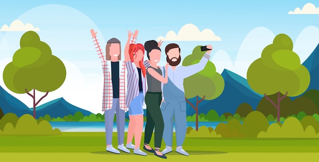 Young people group taking selfie photo on smartphone camera casual friends men women having fun posing outdoor nature landscape mountains background full length horizontal