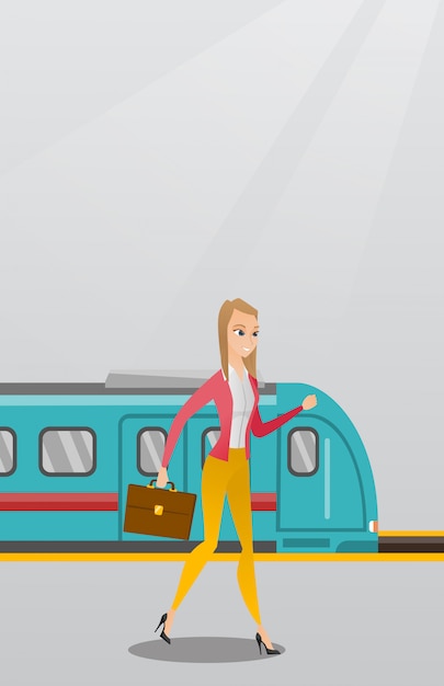 鉄道駅のプラットフォームの上を歩く若い女性。