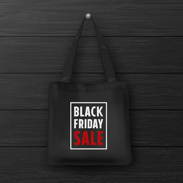 Zwarte stoffen draagtas met het opschrift black friday sale close-up op houten zwarte muur