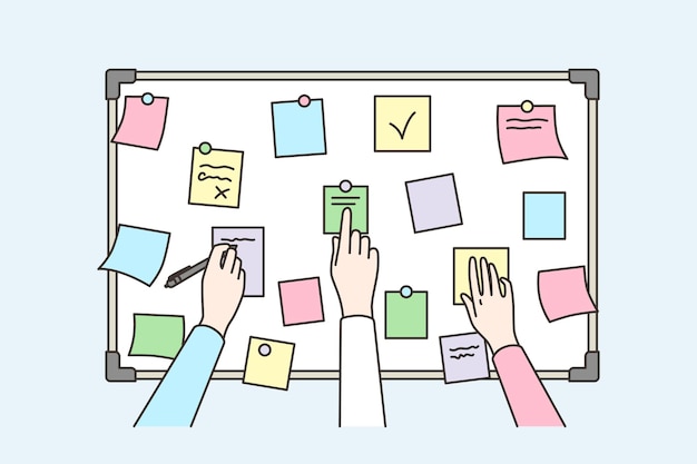 Colleagues brainstorm using sticky notes on board
