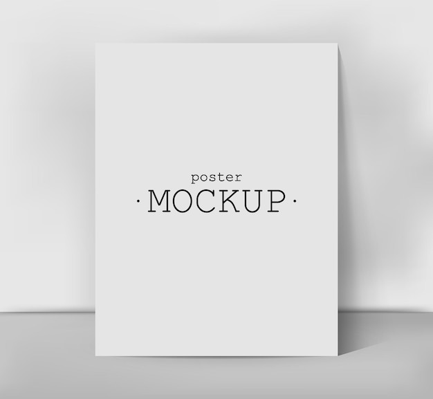 Mockup av poster. Tomt ark som lener seg mot en hvit veggmal