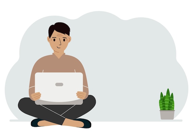 A man sits crosslegged in his hands holding a laptop The concept of work education reading watching videos