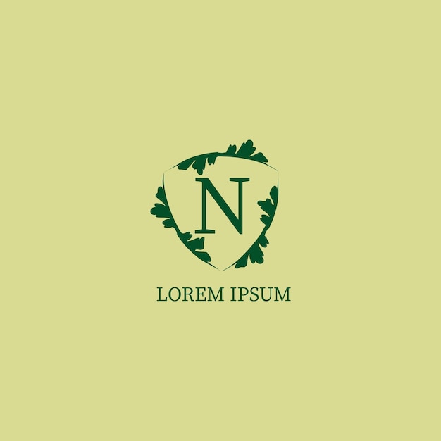 Plik wektorowy litera n alfabetyczny szablon projektu logo na białym tle na zielony kolor beżowy ozdobny kwiatowy tarcza ilustracja znak ochrona przyrody koncepcja logo bezpieczeństwa