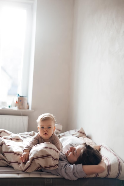 02032022 Winnica Ukraina młoda mama i córeczka obudziły się w łóżku, przytulając się i patrząc na książkę