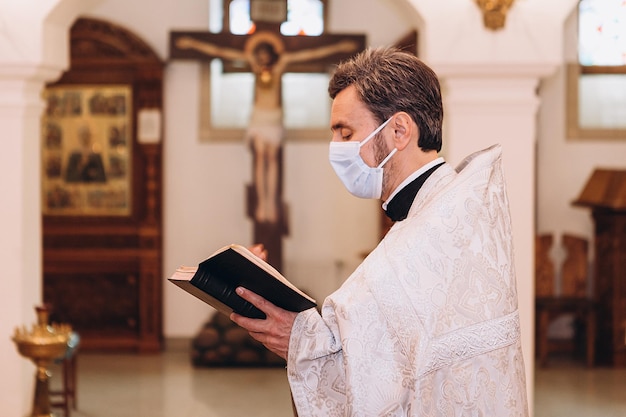 03052020 Winnica Ukraina Prawosławny ksiądz ubrany w strój kapłański i maskę medyczną wykonuje ceremonię podczas epidemii koronawirusa
