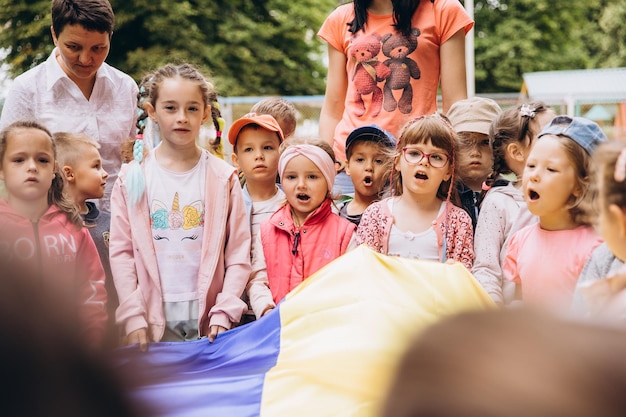 070722 Irpin Ukraina Chrześcijańskie przedszkole Dzieci z ukraińską żółtoniebieską flagą w dłoniach módlcie się za Ukrainę i pokój