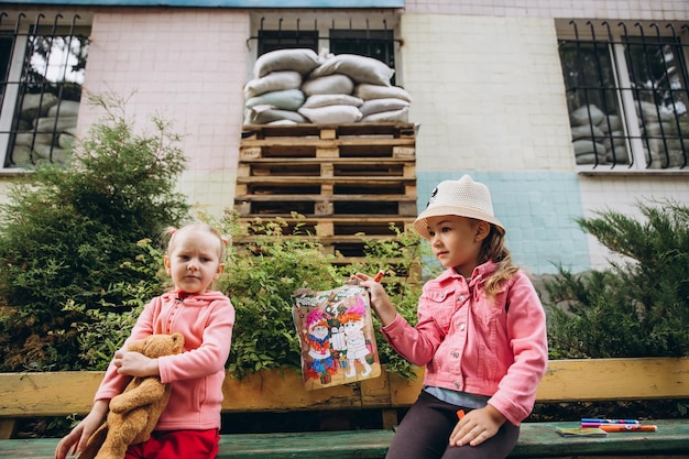 070722 Irpin Ukraina Dzieci z przedszkola bawią się na dziedzińcu budynku, który jest wyłożony wykładziną i zabezpieczony workiem z piaskiem chroniącym przed falą uderzeniową Dni powszednie ukraińskich dzieci