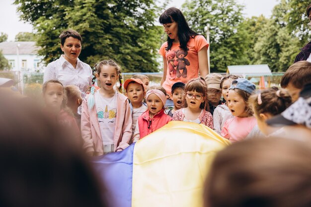 070722 Irpin Ukraina portrety dzieci trzymających dużą ukraińską flagę i śpiewających pieśni patriotyczne