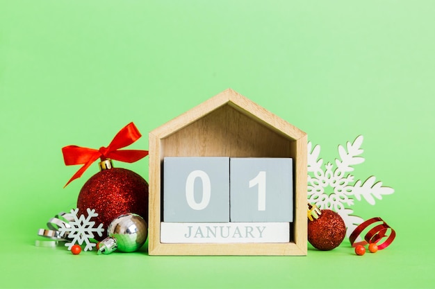 1 stycznia Świąteczna kompozycja na kolorowym tle z drewnianym kalendarzem z pudełkiem na zabawki bombka kopia przestrzeń