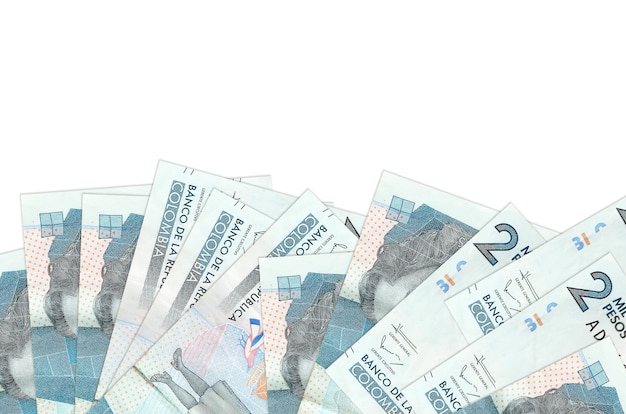 2 rachunki w peso kolumbijskich leży w dolnej części ekranu na białym tle na białej ścianie z miejsca na kopię.