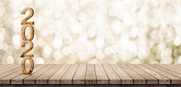 Zdjęcie 2020 szczęśliwego nowego roku drewna numer na stole z drewna z błyszczącą złotą ścianą bokeh