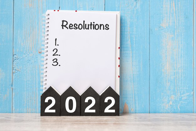 2022 Szczęśliwego Nowego Roku ze słowem RESOLUTIONS i drewnianym numerem. czas na Nowy Start, Cel, Plan, Działania i Koncepcję Misji