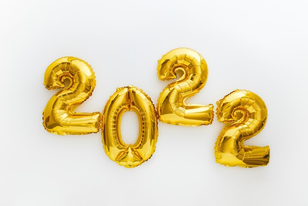 2022 złote balony tekst szczęśliwego nowego roku zaproszenie z kalendarzem świątecznych balonów złota folia. 2022 balon liczbowy na białym tle na obchody Bożego Narodzenia i nowego roku. Długi baner internetowy.