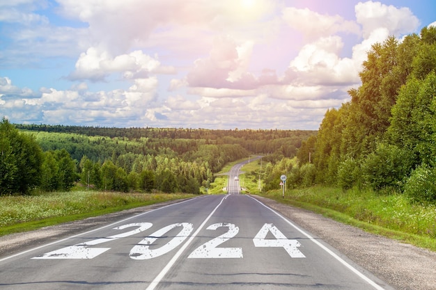Zdjęcie 2024 napisany na autostradzie po środku pustej drogi asfaltowej i pięknego błękitnego nieba. pojęcie
