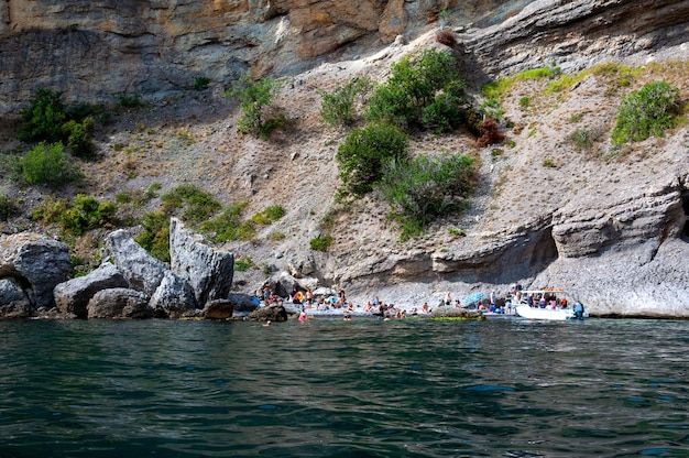 27 sierpnia 2021 Republika Krymu przedmieścia miasta Novy Svet wstępniak Ludzie pływają w małej skalistej zatoce Mała dzika plaża