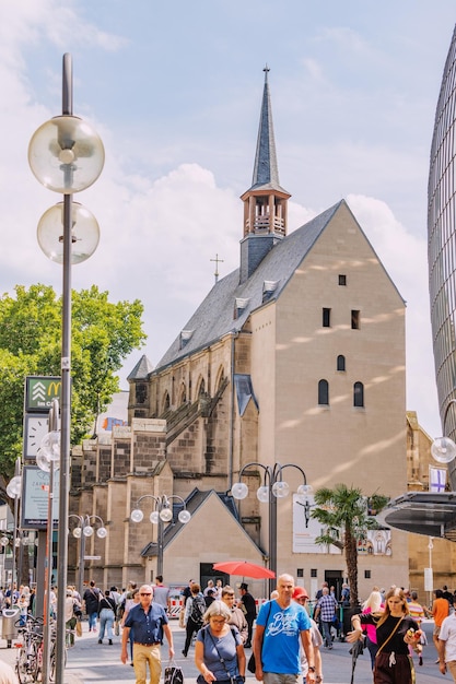 29 lipca 2022 Kolonia Niemcy Ludzie chodzą i robią zakupy na deptaku z pięknym kościołem Antoniterkirche