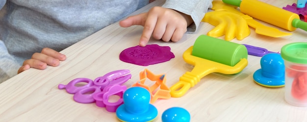 3 lata dziewczyna sztuki twórczej. Ręce dziecka bawiące się kolorową glinianą plasteliną. Samoizolacja Covid-19, edukacja online, nauczanie domowe. Toddler dziewczyna studiuje w domu, nauka w domu.