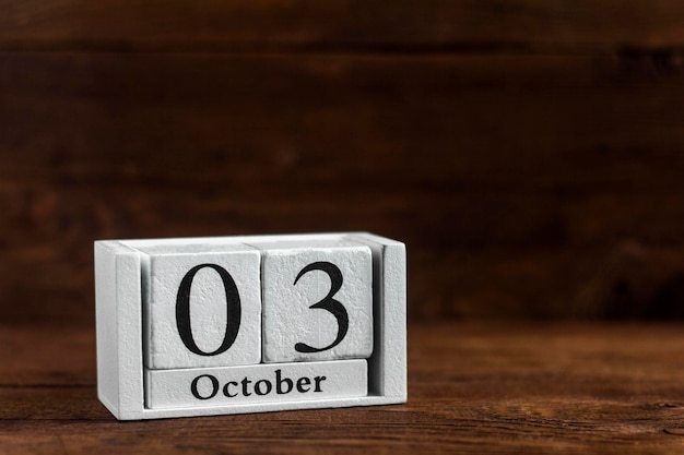 3 października w kalendarzu na ciemnym tle drewnianych. Data miesiąca jesiennego.