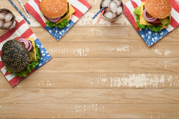 4 lipca Amerykański Dzień Niepodległości tradycyjny piknik jedzenie Amerykański Burger i koktajl Amerykańskie flagi i symbole USA Patriotyczny piknik wakacje na białym drewnianym tle Widok z góry