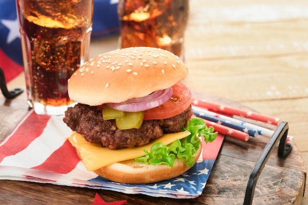 4 lipca Amerykański Dzień Niepodległości tradycyjny piknik jedzenie Amerykański Burger i koktajl Amerykańskie flagi i symbole USA Patriotyczny piknik wakacje na białym drewnianym tle Widok z góry