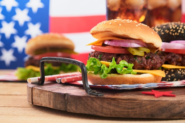 4 lipca Amerykański Dzień Niepodległości tradycyjny piknik jedzenie Amerykański Burger i koktajl Amerykańskie flagi i symbole USA Patriotyczny piknik wakacje na białym drewnianym tle Widok z góry