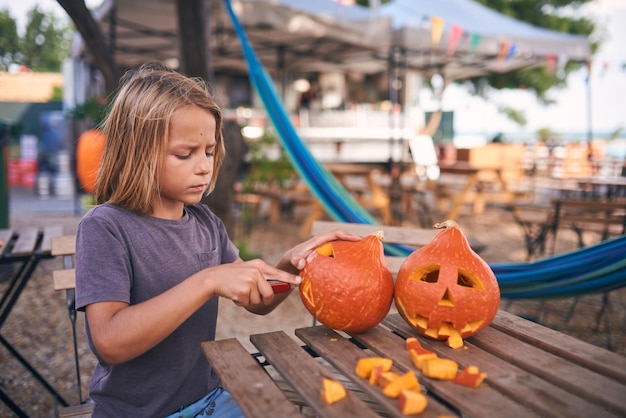 8-letni chłopiec rzeźbi dynię na Halloween