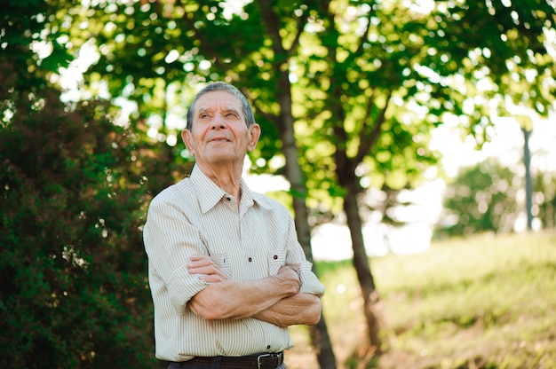 80-letni mężczyzna pozowanie w parku lato.