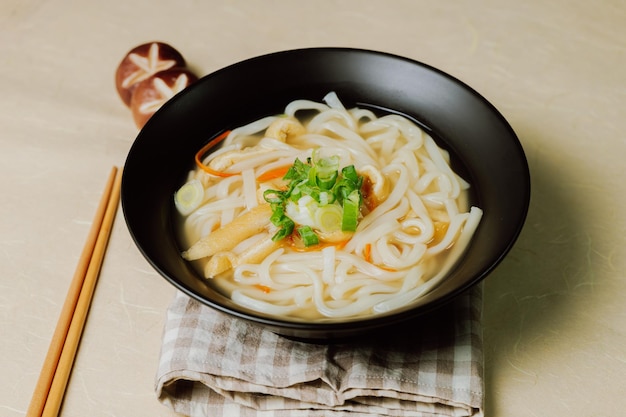 Zdjęcie 검은색 그릇에 담긴 한국 음식 멸치 칼국수 요리