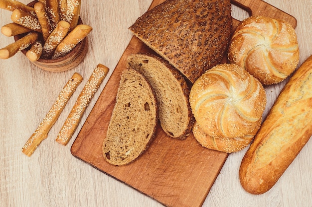 Ă Â¡ risp chleb z bułeczkami. Francuskie bagietki. Świeże pieczywo chrupkie. Chleb tło. Różne rasy na drewnianym tle.