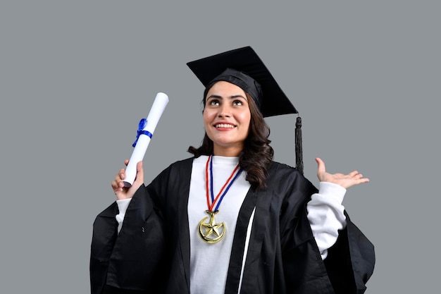 Absolwentka studentka podekscytowana trzymająca dyplom w ręku indyjski model pakistański