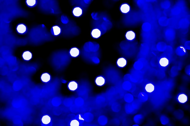 Abstrakcjonistyczni błękitni bożego narodzenia bokeh światła odizolowywający na czarnym tle. Ba lekkie choinki