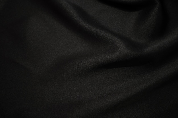 Abstrakcyjna czarna satyna jedwabista tkanina tekstylna zasłona z fałdami falistymi fałdami w tle