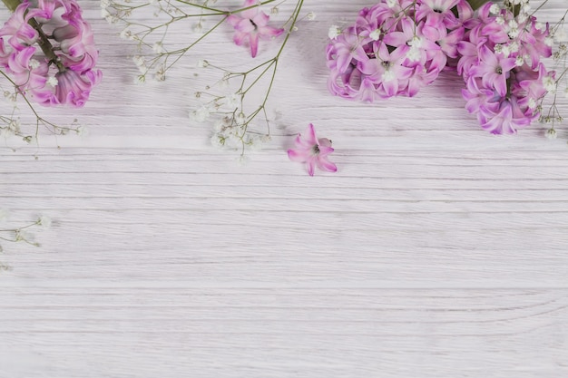 Abstrakcyjna kompozycja świeżych fioletowych kwiatów Hiacynt na białej rustykalnej powierzchni drewnianej. Wzór z różnych kwiatów. Delikatna wiosenna kwiatowa powierzchnia, świąteczna pocztówka. Płaskie miejsce na tekst