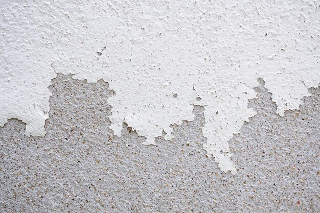 Abstrakcyjna stara biała betonowa ściana z łuszczącą się farbą